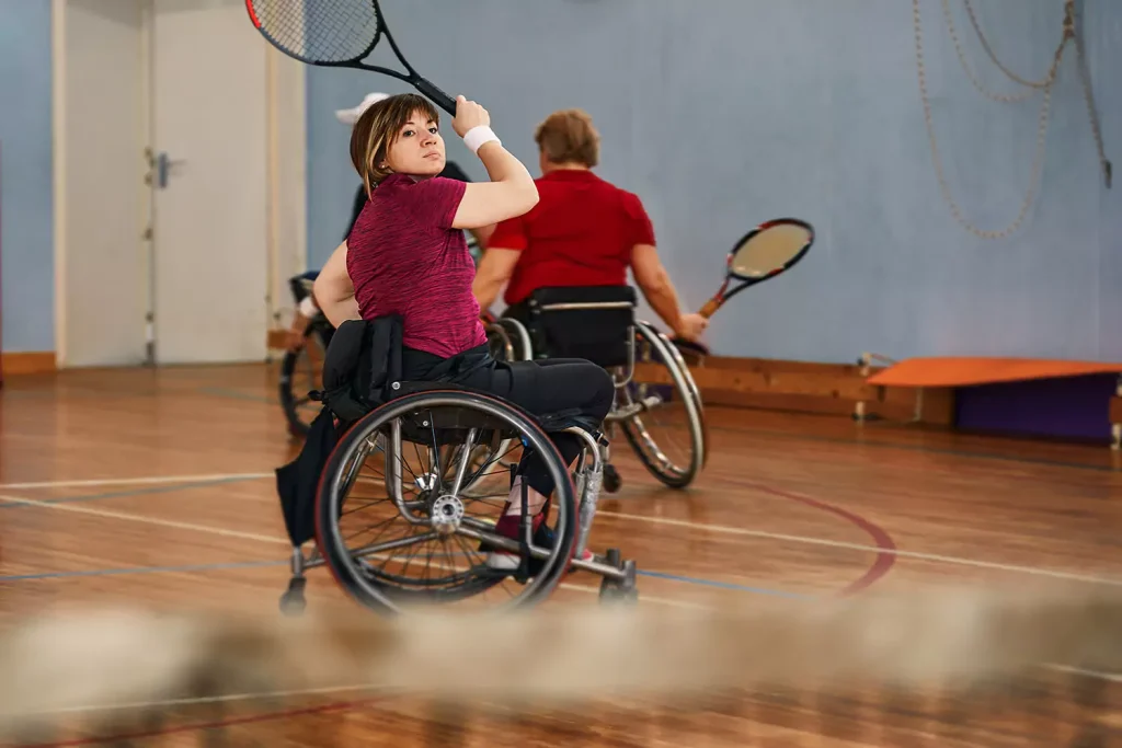 A disabled woman in her wheelchair is playing tennis